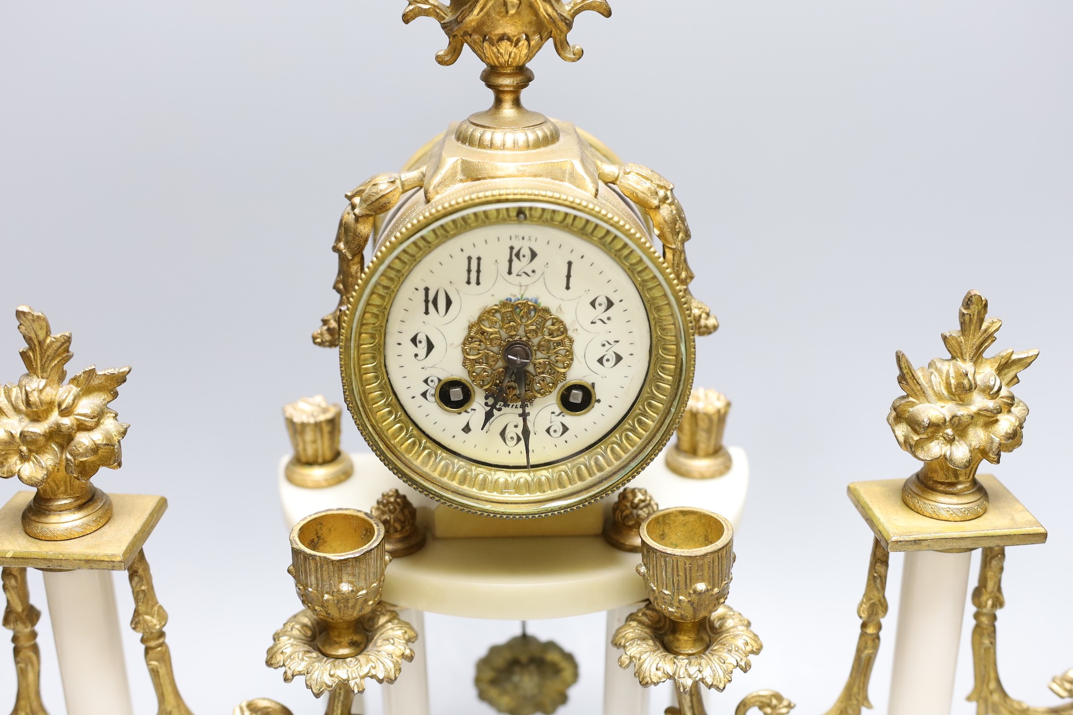 A French white marble and gilt metal clock garniture, 43 cms high